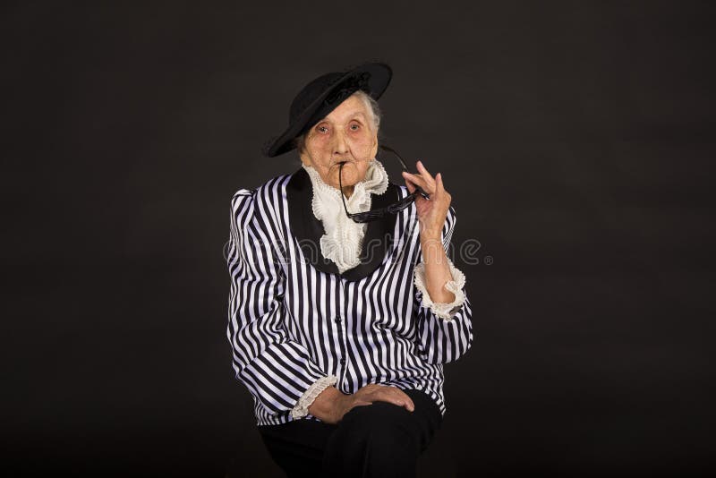 Παλαιό grandma σε ένα άσπρος-μαύρο ριγωτό σακάκι στοκ εικόνες